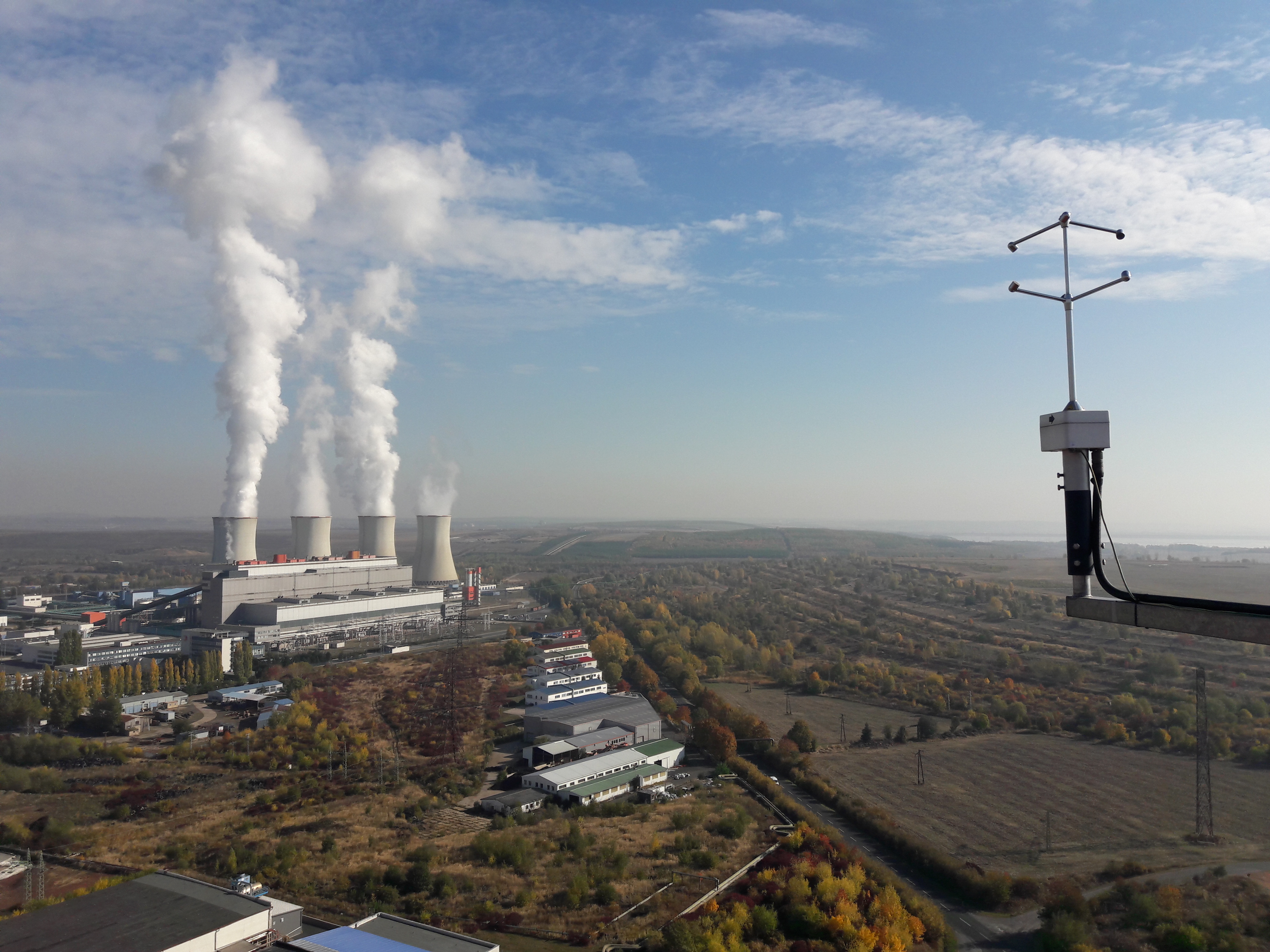 Anemometr umístěný na vrcholu meteorologického stožáru s výhledem na Elektrárnu Tušimice